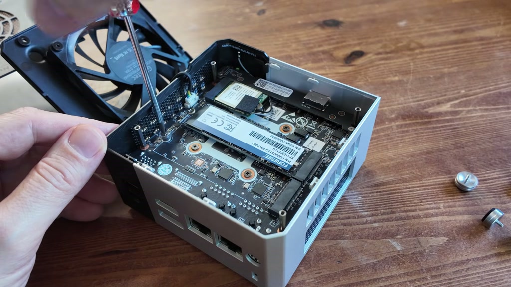 Mini PC opened to show internal NVMe storage slots during the cloning process